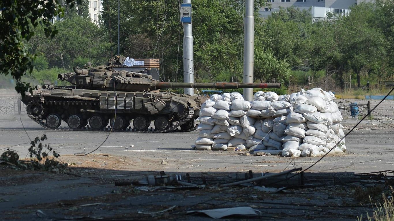 Ein russischer Panzer fährt durch eine Straße in der Region Luhansk (Archivbild): Der militärische Druck auf ukrainische Städte wächst.