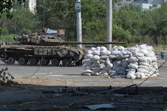 Ein russischer Panzer fährt durch eine Straße in der Region Luhansk (Archivbild): Der militärische Druck auf ukrainische Städte wächst.