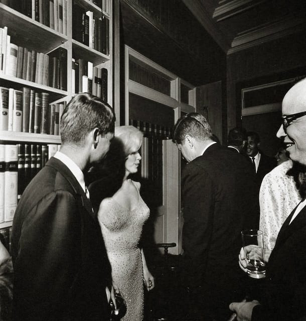 Marilyn Monroe: Hier sieht man die Schauspielerin im Jahr 1962 zwischen Robert F. und John F. Kennedy in dem Kleid, das Kim Kardashian Jahrzehnte später zur Met Gala trug.