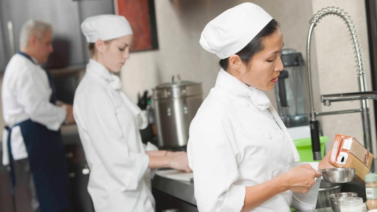 Köchinnen in einer Restaurantküche (Symbolbild): Der Personalmangel könnte die Schließung von Restaurants bedeuten.