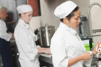 Köchinnen in einer Restaurantküche (Symbolbild): Der Personalmangel könnte die Schließung von Restaurants bedeuten.