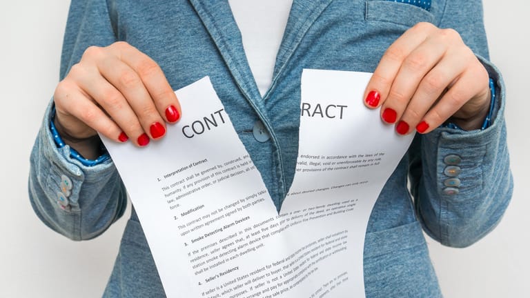 Eine Frau zerreißt einen Vertrag (Symbolbild): Ab dem 1. Juli soll es einfacher werden Verträge online zu kündigen.