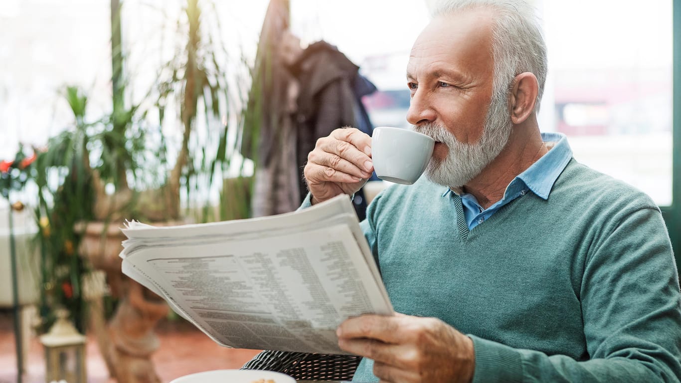 Ein älterer Mann trinkt einen Kaffee.