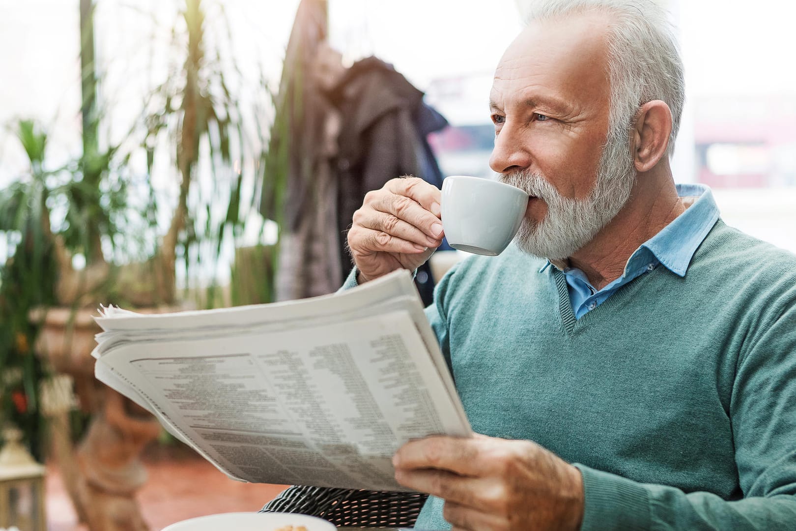 Ein älterer Mann trinkt einen Kaffee.