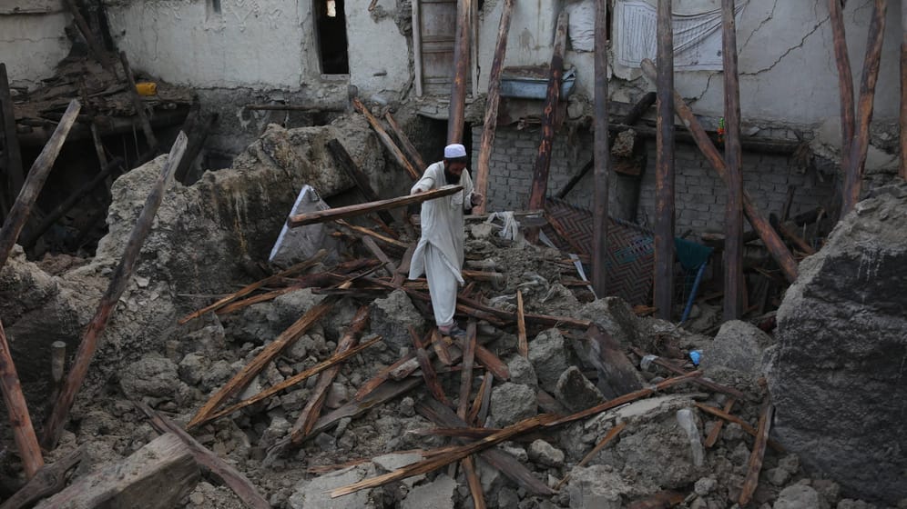 Ein Mann steht in einer Häuserruine: Das Erdbeben hat mindestens tausend Tote gefordert und zahlreiche Gebäude zerstört.