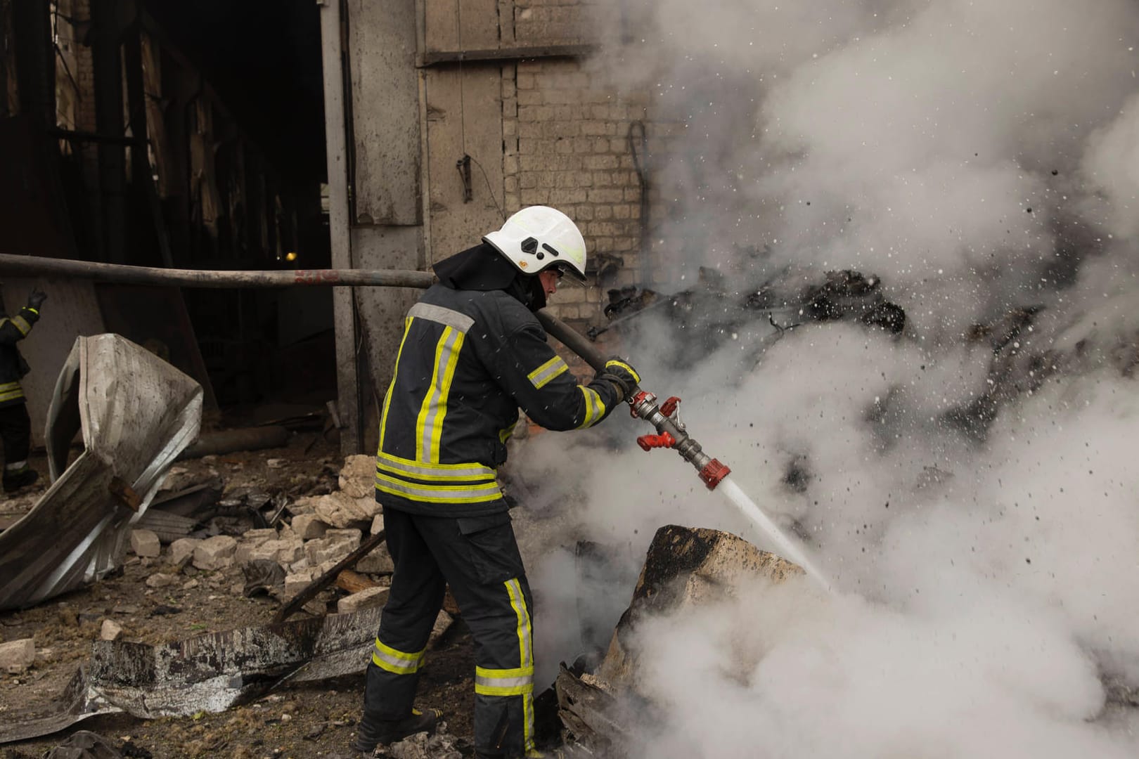 Ein Feuerwehrmann löscht einen Brand nach einem Angriff in Charkiw (Archivbild): Aus der Stadt wurden am Samstag Explosionen gemeldet.