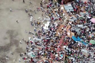 Kolumbien, El Espinal: In diesem Videostandbild stürzen Zuschauer zu Boden, als ein Teil einer Holztribüne während eines Stierkampfes zusammenbricht.