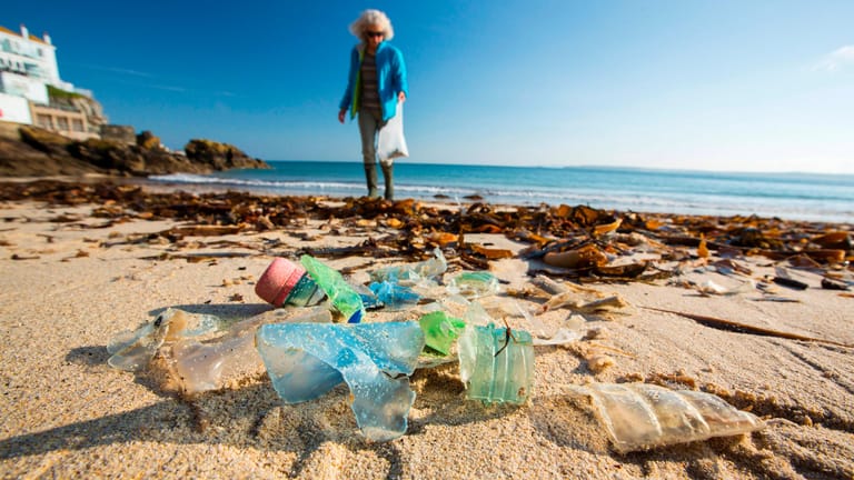 Eine Plastikflasche am Strand (Symbolbild): Die Vermüllung von Meer und Stränden wird zunehmend zum Problem.