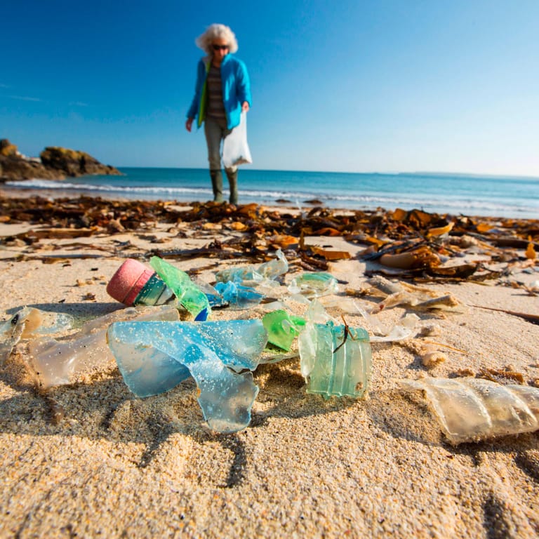 Eine Plastikflasche am Strand (Symbolbild): Die Vermüllung von Meer und Stränden wird zunehmend zum Problem.