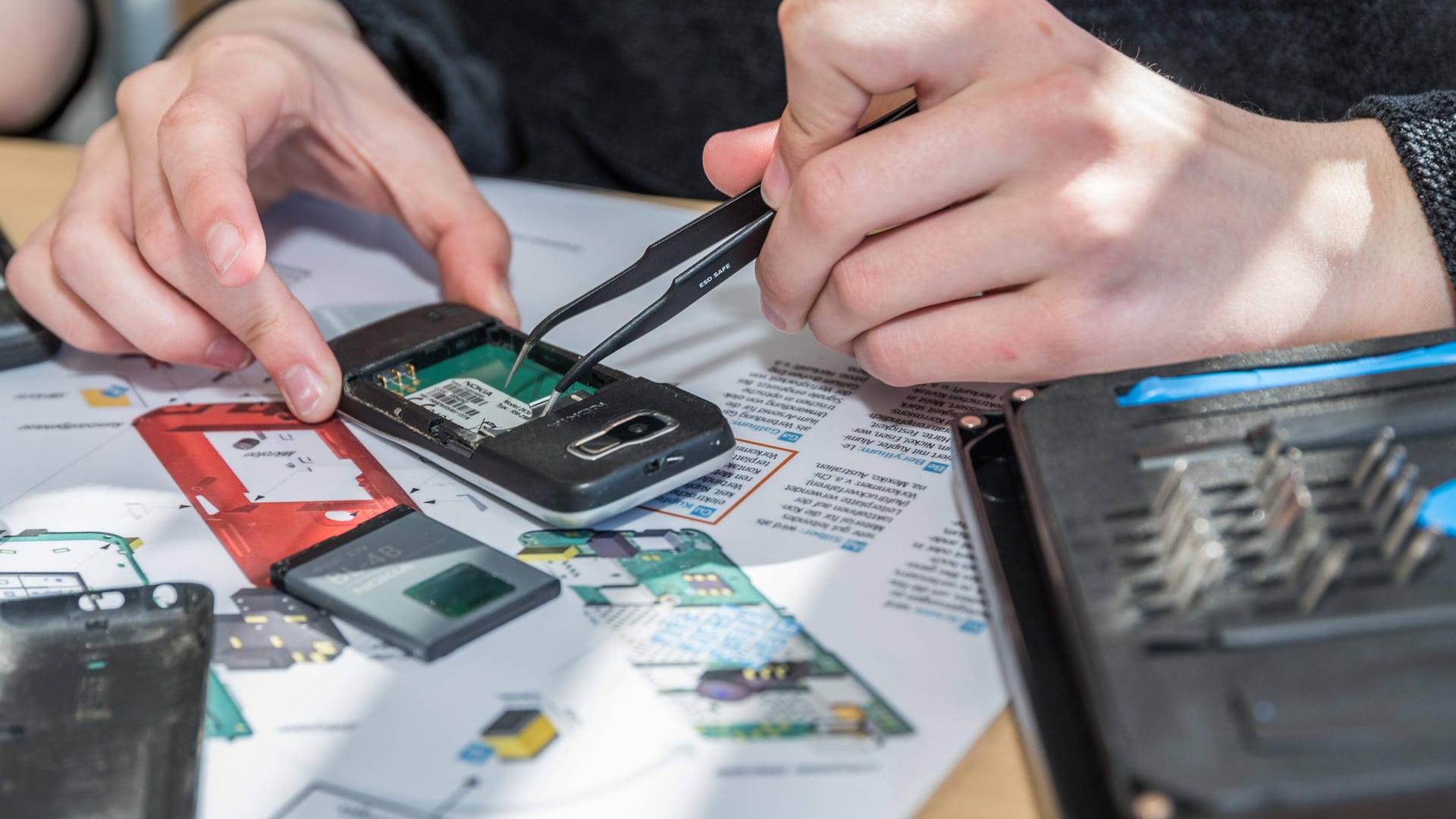 Techniker zerlegt altes Handy (Symbolbild): Insbesondere Kobalt, Silizium, Magnesium und Lithium sind wichtige Mineralien für Technologien.