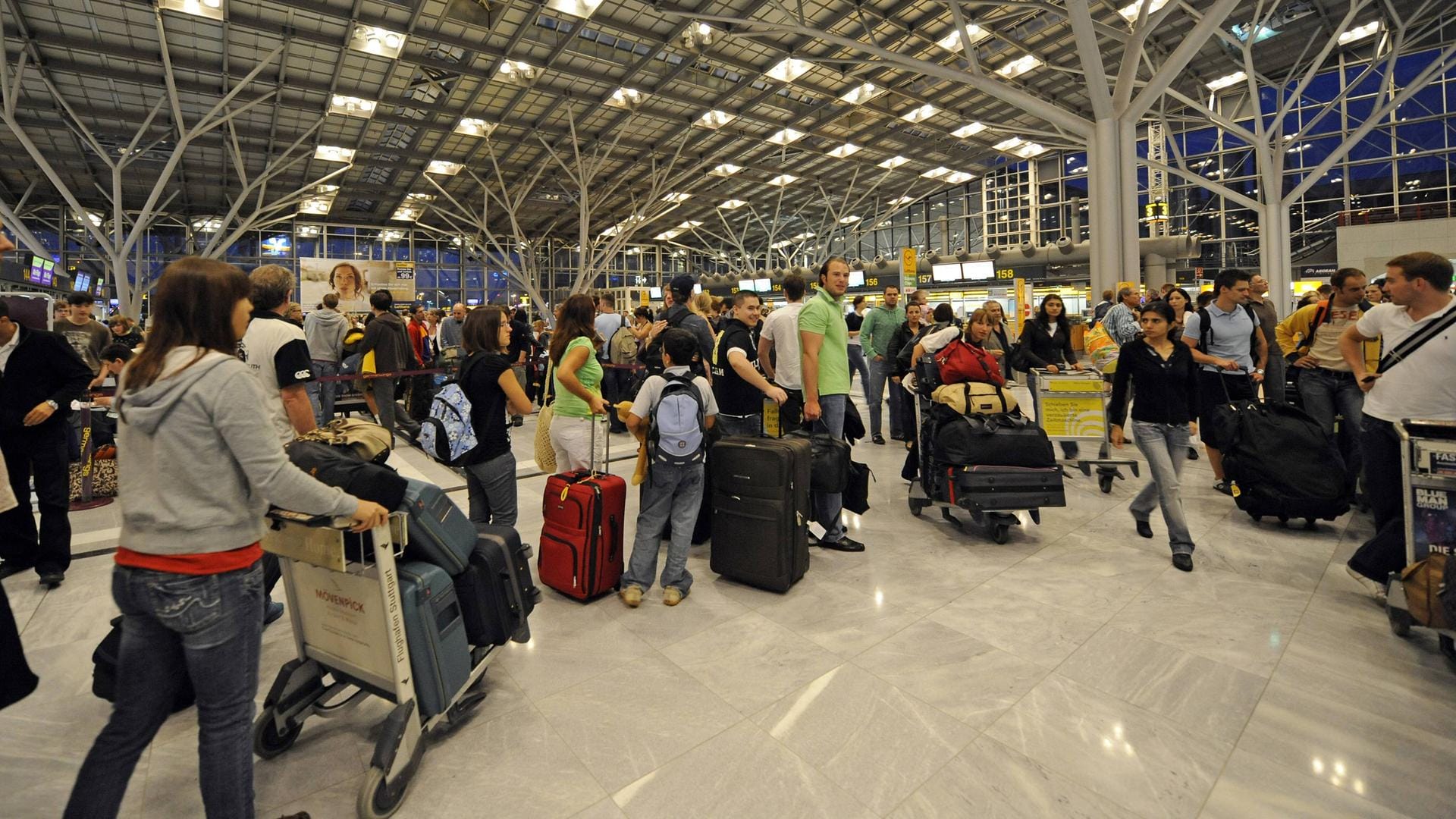 Reisende in einer Warteschlange vor Check-in-Schaltern am Flughafen Stuttgart: Viele Airports sind überlastet.