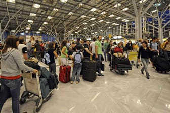 Reisende in einer Warteschlange vor Check-in-Schaltern am Flughafen Stuttgart: Viele Airports sind überlastet.