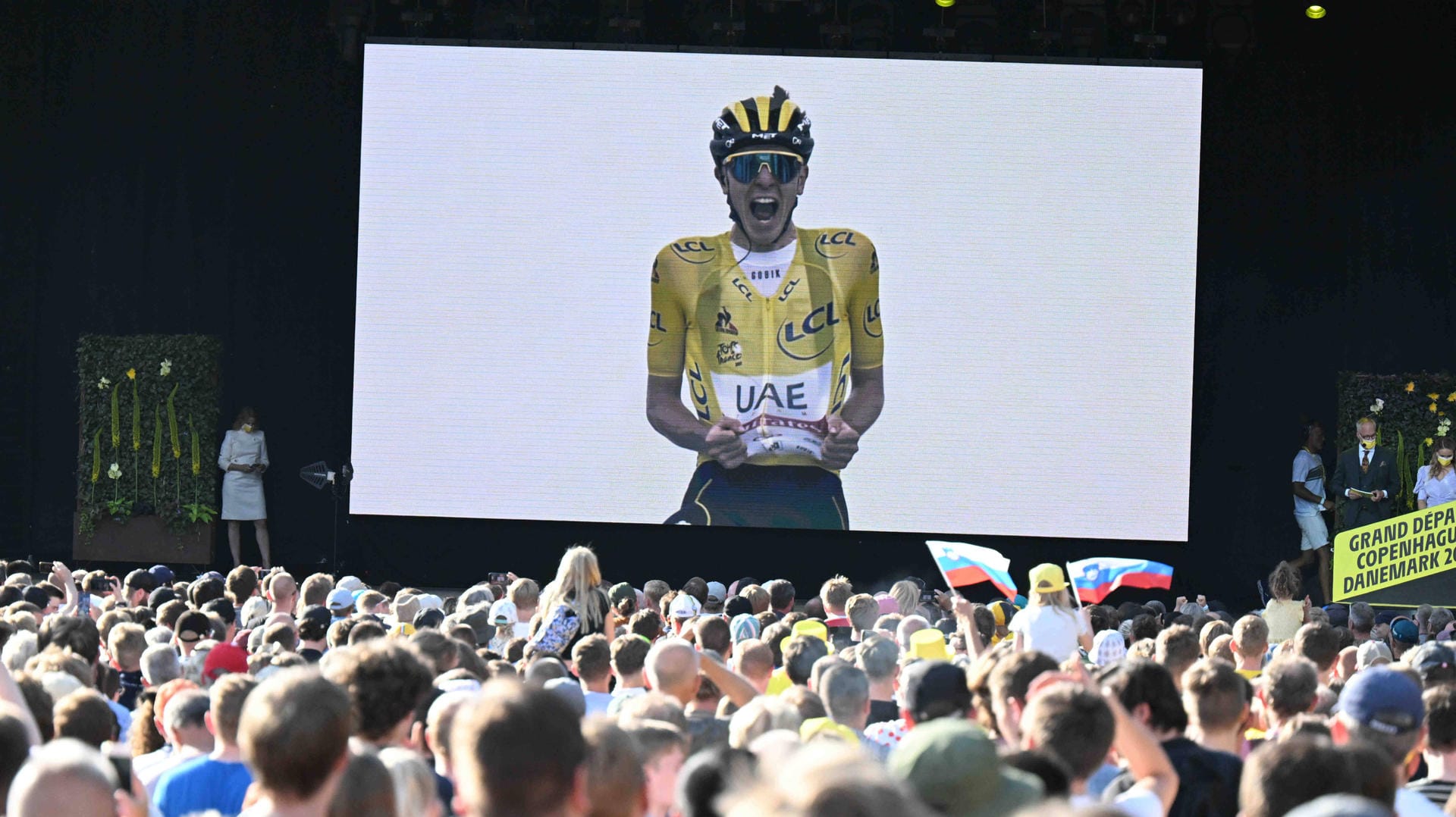 Tadej Pogacar auf großem Bildschirm: Bei der Tour-Vorstellung in Kopenhagen wurde der Gelb-Coup des Slowenen aus dem Vorjahr nochmal in Highlights gezeigt.