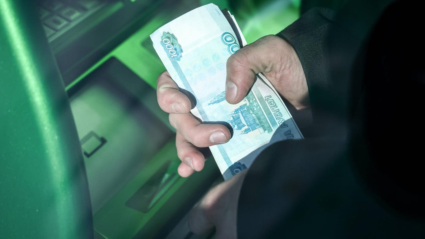Ein Mann hebt Geld an einem Automaten in Moskau ab (Symbolbild): Der Rubelkurs ist in den vergangenen Monaten erst deutlich abgestürzt und dann in ungeahnte Höhen geschnellt.