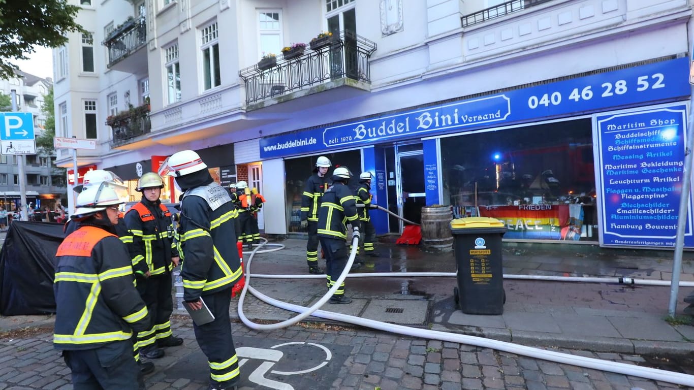 Einsatzkräfte der Feuerwehr löschen das Feuer im Ladenlokal.