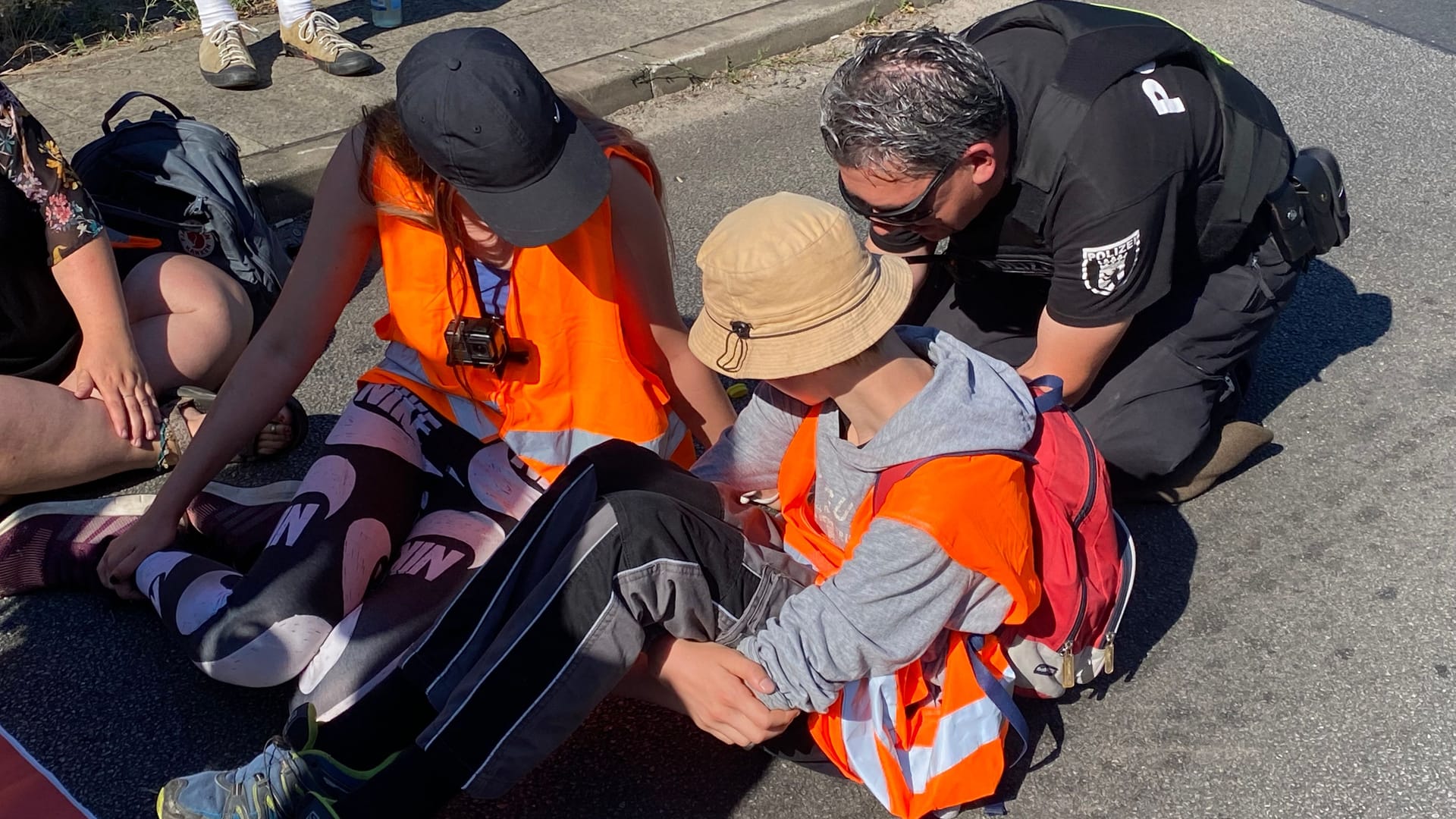 Ein Polizist löst den Kleber: Auch zwei Minderjährige haben sich am Freitag an der Autobahnblockade beteiligt.