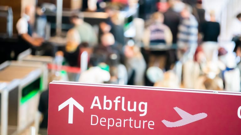 Menschen stehen am Flughafen Berlin Brandenburg (BER) an der Sicherheitskontrolle (Archivbild): Die Sommerferien stehen kurz bevor.