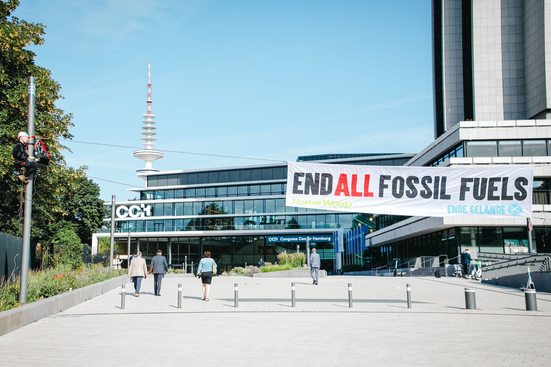 Ein Aktivist hängt an einem Laternenmast vor dem Congress Center Hamburg, an dem ein Banner befestigt ist: Am Mittwochmorgen kam es zu einer Protestaktion gegen Erdgas.