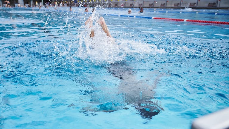 Ein Kind springt in einem Schwimmbad ins Becken (Symbolbild): Ein Schwimmtrainer soll Kinder zwischen 8 und 13 Jahren missbraucht haben.