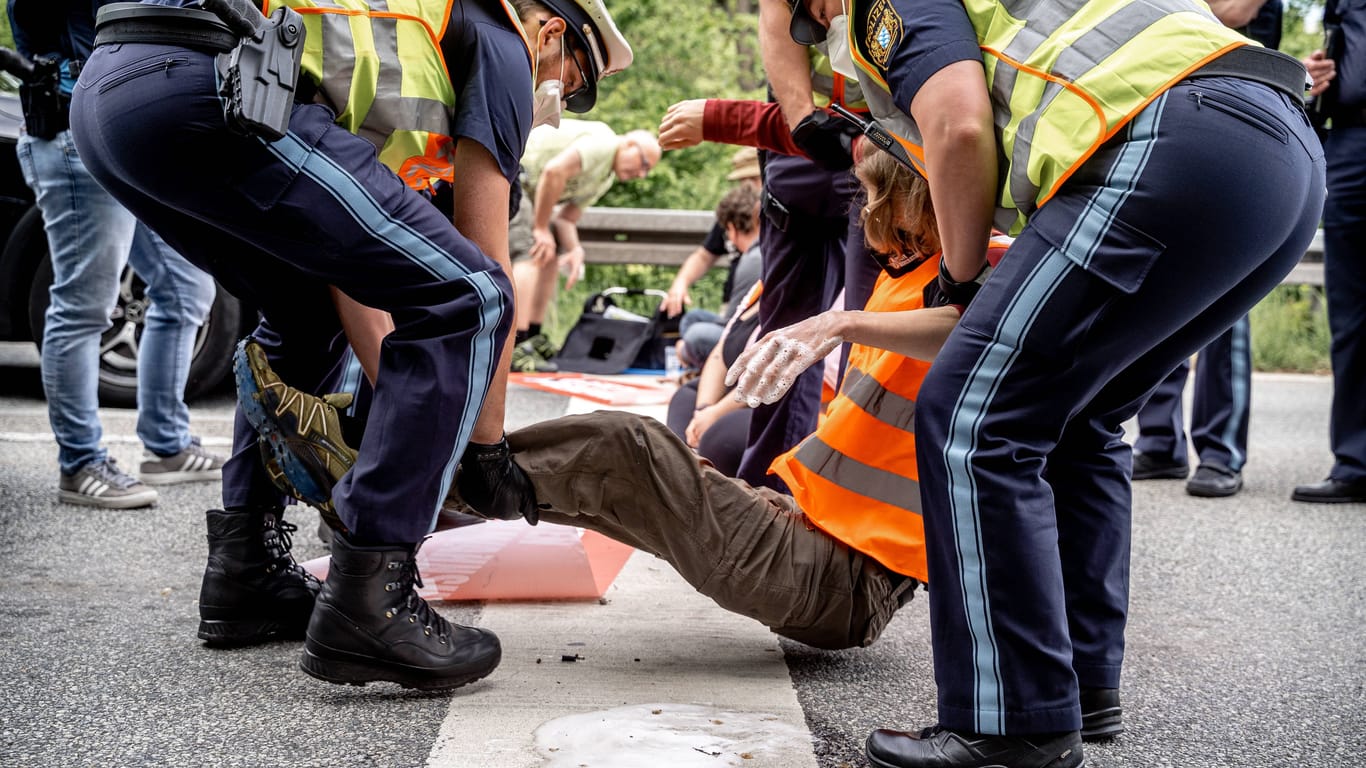 Polizisten tragen einen Klimaaktivisten von der Straße (Archivbild): Auslöser für die Aktion sei eine Ankündigung von FDP und Grünen.