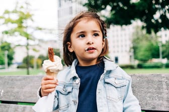 Ein Mädchen hält eine Eiswaffel in einem Park (Symbolbild): Die Rekordtemperaturen schreien nach kreativen Eissorten.