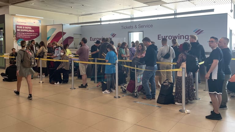 Reisende warten vor einem Service-Schalter von Eurowings: Manchen von ihnen wurden kurzfristig die Flüge gestrichen.