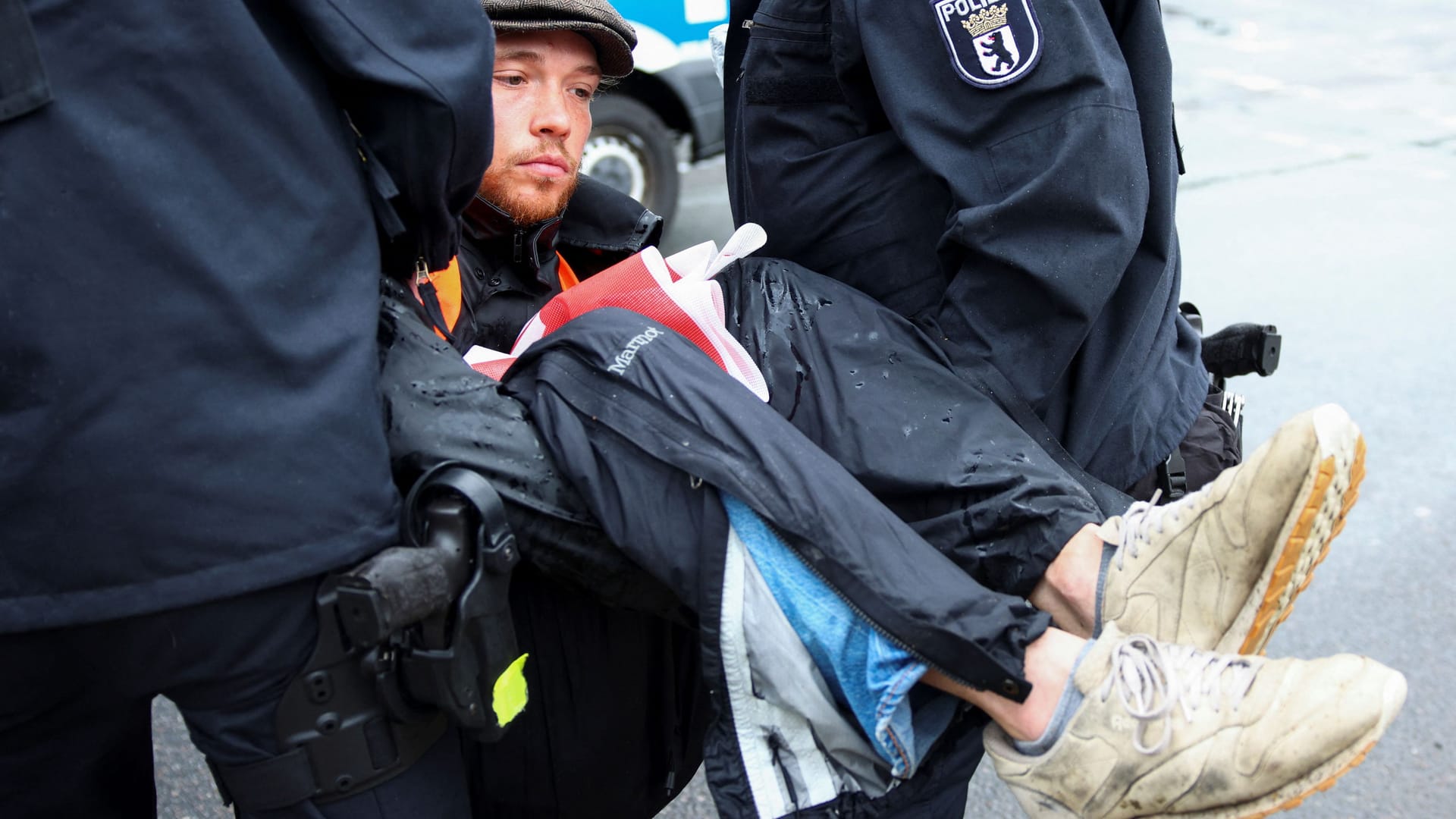 Ein Aktivist wird von der Straße getragen: Viele kleben sich mit den Händen an der Straße fest, um der Polizei die Arbeit zu erschweren.