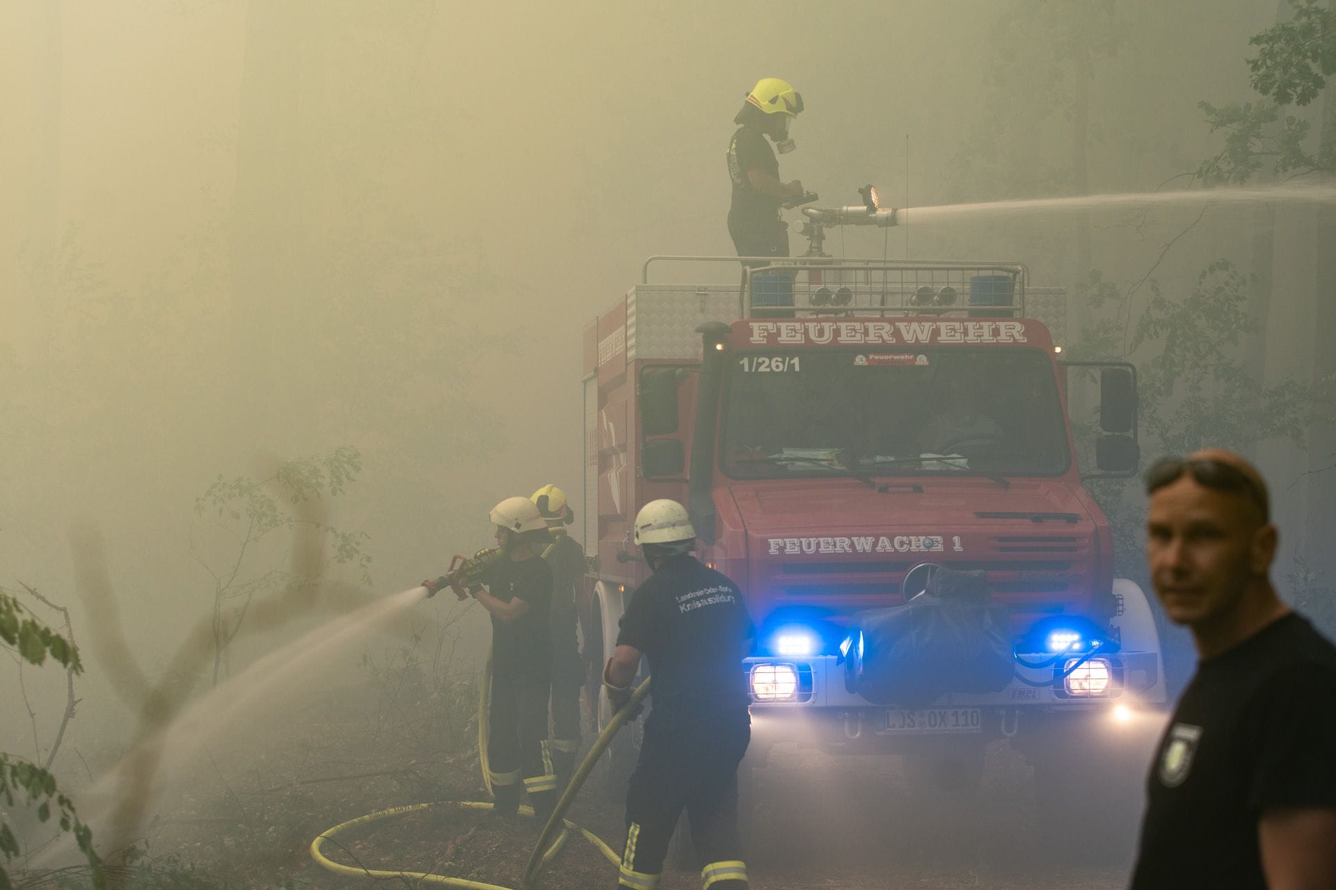 Ein Löschwagen mitten im Geschehen: Im dichten Qualm kämpfen die Retter gegen das Feuer, ohne Atemschutzmaske nur schwer auszuhalten.