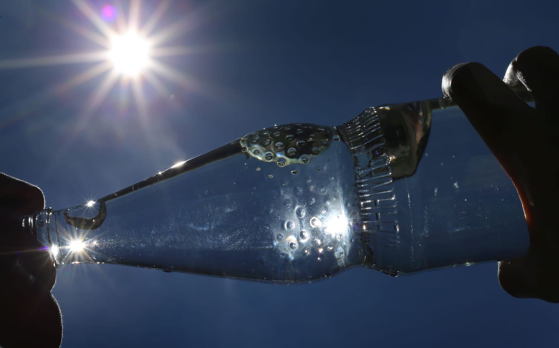 Eine Frau trinkt Mineralwasser aus einer Flasche