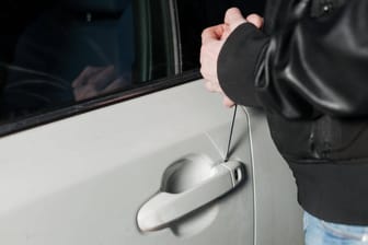 Eine Person bricht ein Auto auf (Symbolbild): Ein Raubkommissariat ermittelt.