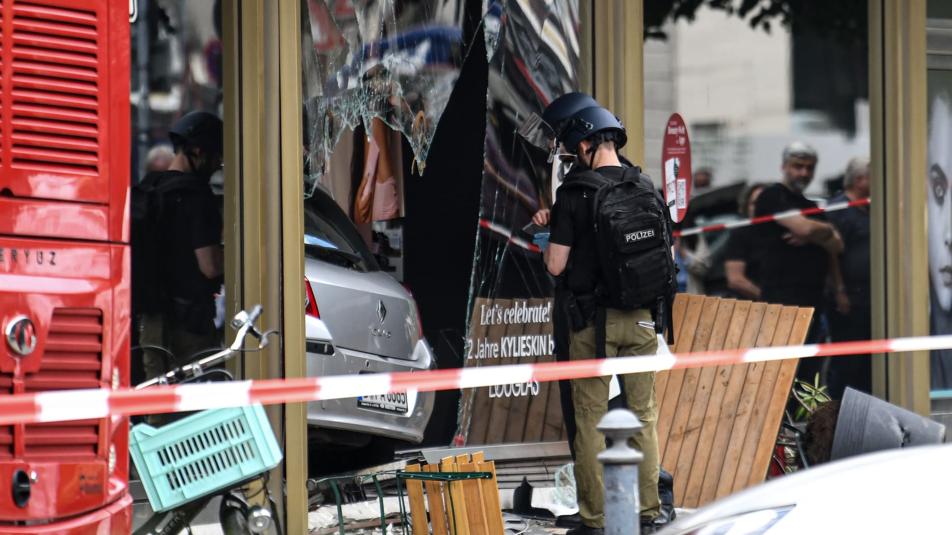 Die Polizei sichert Spuren an einem zerbrochenen Schaufenster: Die Polizei ermittelt zu den Hintergründen.