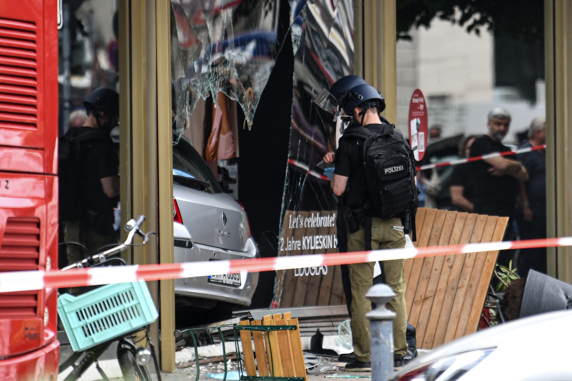 Die Polizei sichert Spuren an einem zerbrochenen Schaufenster: Die Polizei ermittelt zu den Hintergründen.