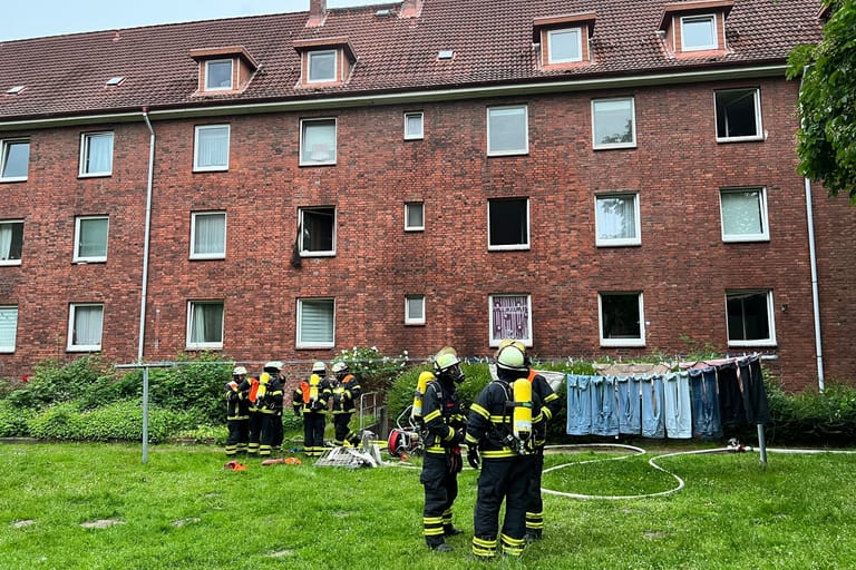 Einsatzkräfte der Feuerwehr vor dem Mehrfamilienhaus: Im Keller des Gebäudes brannte es.