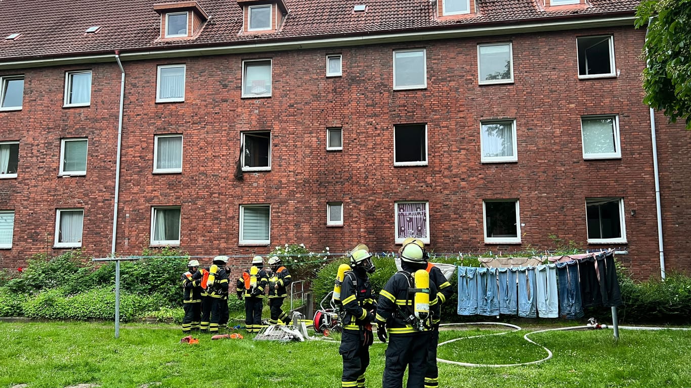 Einsatzkräfte der Feuerwehr vor dem Mehrfamilienhaus: Im Keller des Gebäudes brannte es.