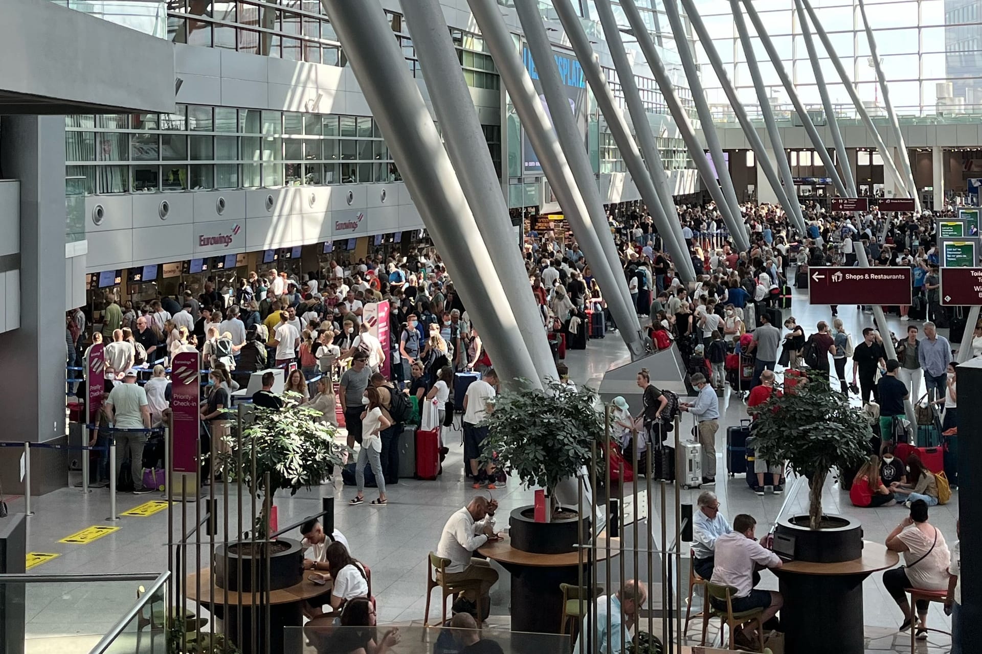 Menschenmassen am Flughafen Düsseldorf zum Ferienbeginn. Das Personal fehlt und die Technik streikt auch manchmal.