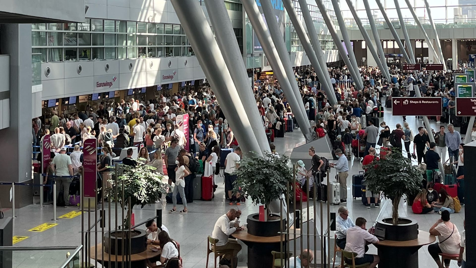 Menschenmassen am Flughafen Düsseldorf zum Ferienbeginn. Das Personal fehlt und die Technik streikt auch manchmal.