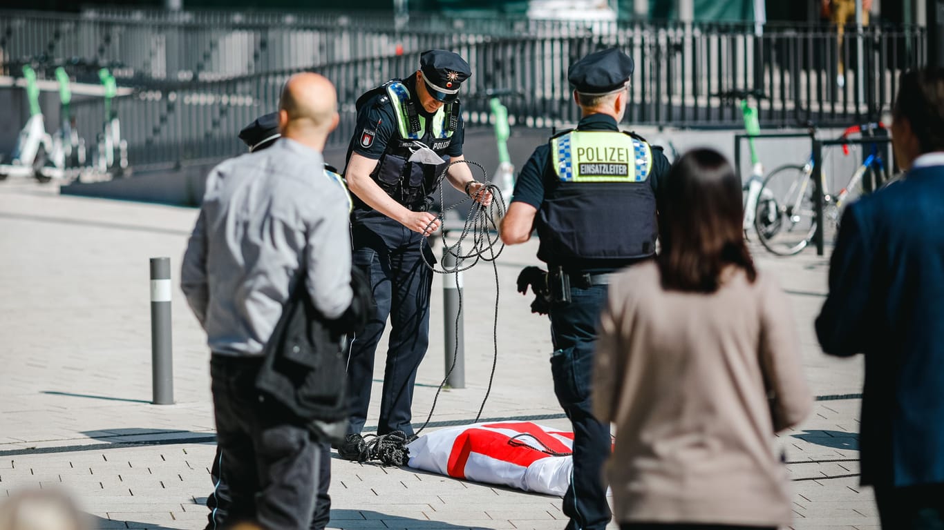 Polizisten beschlagnahmen ein Protestbanner: Die Aktion vor dem Congress Center Hamburg wurde nach weniger als einer Stunde beendet.