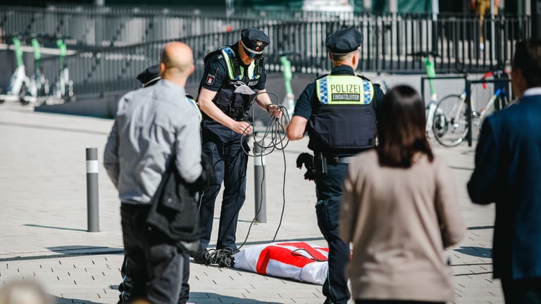 Polizisten beschlagnahmen ein Protestbanner: Die Aktion vor dem Congress Center Hamburg wurde nach weniger als einer Stunde beendet.
