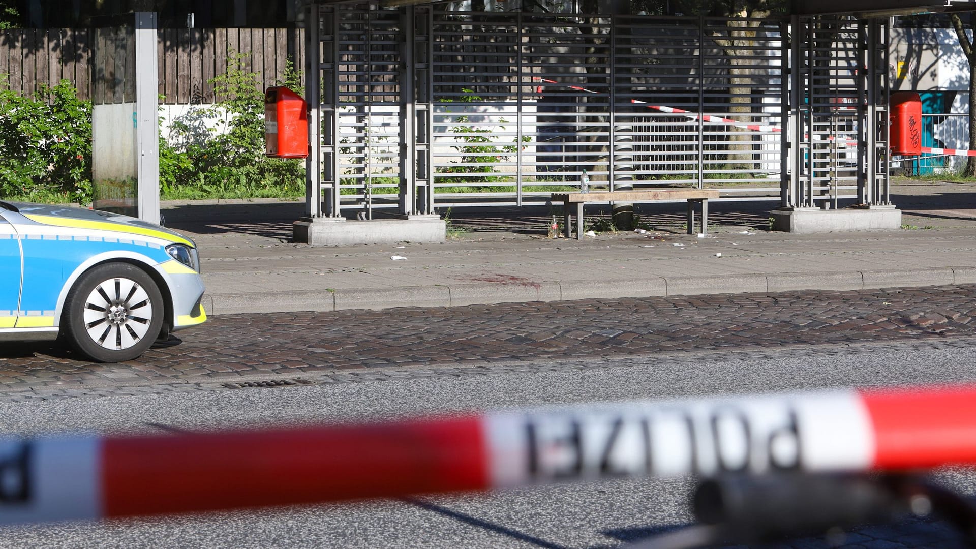 Blut ist auf dem Boden vor einer Bushaltestelle zu sehen. Die Polizei sucht noch nach dem Täter. Blut ist auf dem Boden vor einer Bushaltestelle zu sehen. Die Polizei sucht noch nach dem Täter.