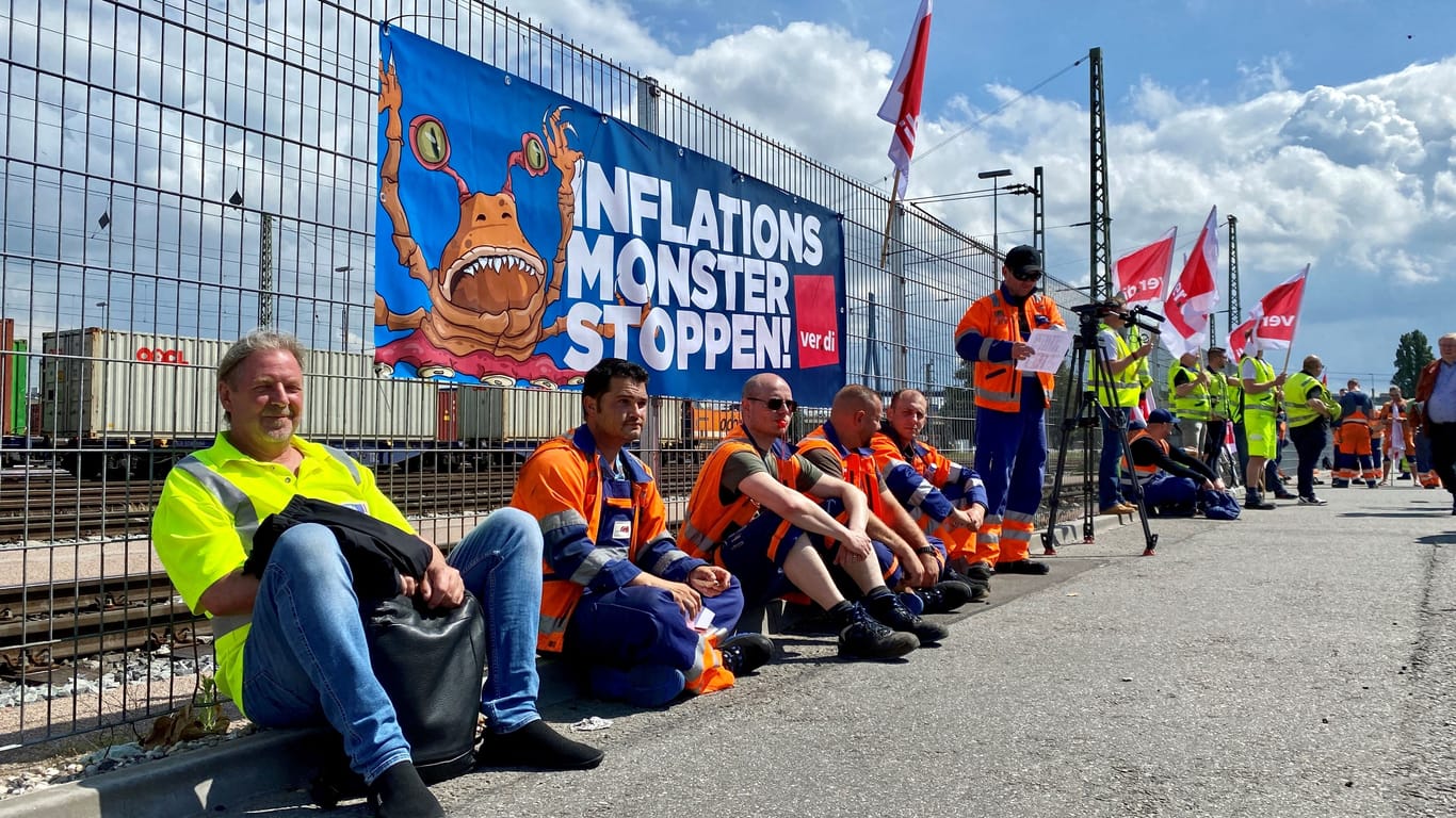 Hafenarbeiter beim Streik im Hafen sitzen vor einem Plakat der Gewerkschaft Verdi: Insgesamt 1200 Beschäftigte sollen sich am Donnerstag am Warnstreik in Hamburg beteiligt haben.