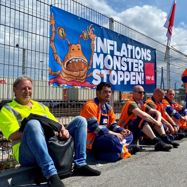 Hafenarbeiter beim Streik im Hafen sitzen vor einem Plakat der Gewerkschaft Verdi: Insgesamt 1200 Beschäftigte sollen sich am Donnerstag am Warnstreik in Hamburg beteiligt haben.