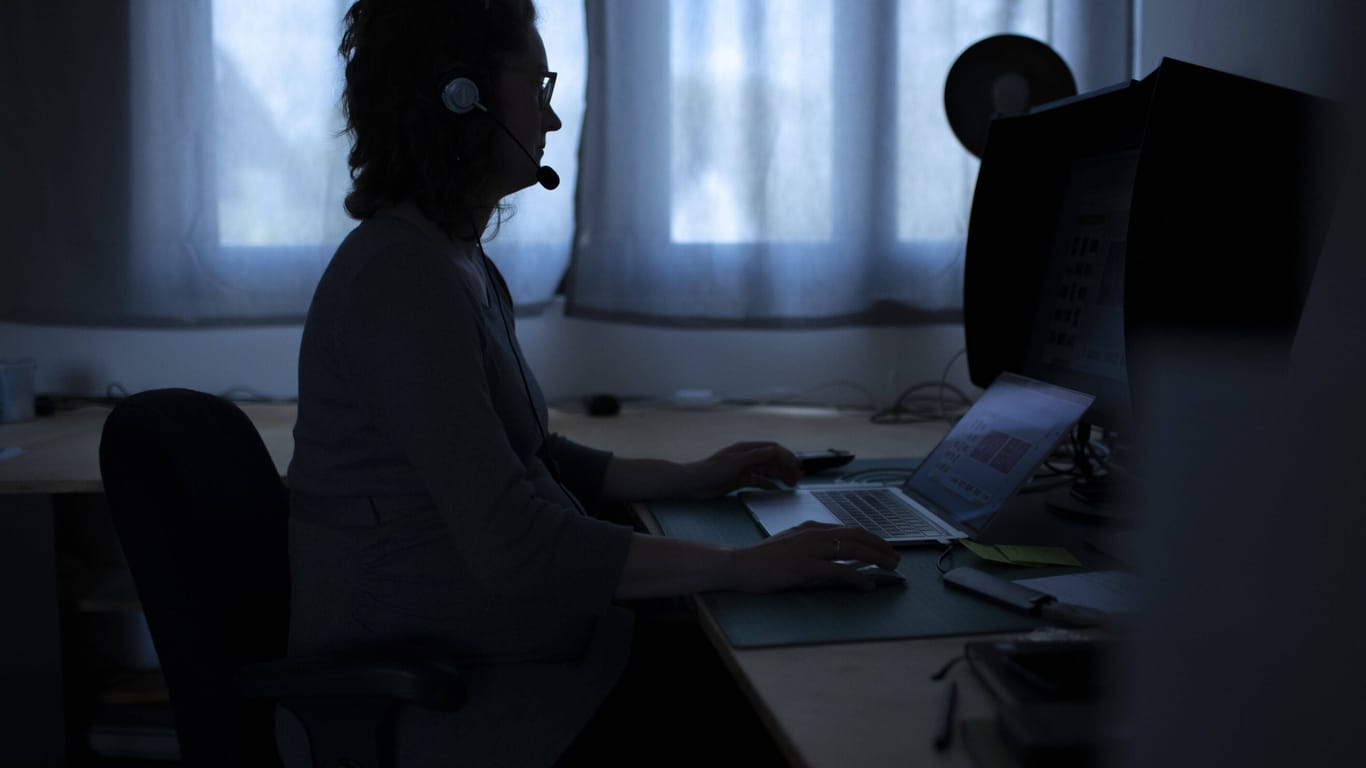 Eine Frau sitzt an einem Computer (Symbolbild): Sie Ermittlungen zu Corona-Betrugsfällen dauern in Berlin an.