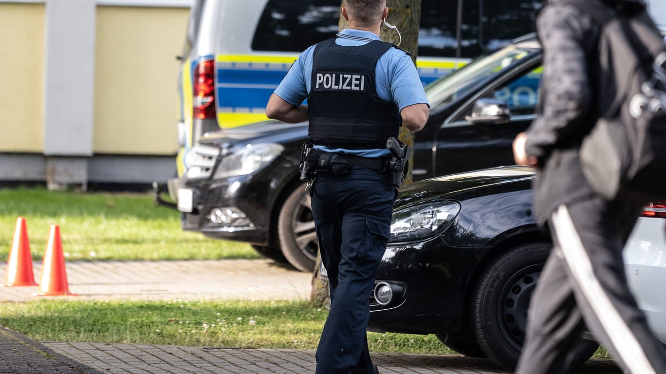 Ein Polizist steht vor Schulbeginn auf einem Parkplatz der Haupt- und Realschule Kaulbach-Schule im nordhessischen Bad Arolsen: Eine Lehrerin der Schule war in Berlin getötet worden.