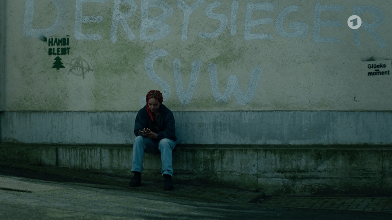 Die Szene aus dem Hamburger "Tatort": Nana Leopold (gespielt von Gina Haller) sitzt vor dem Graffiti "Derbysieger SVW".