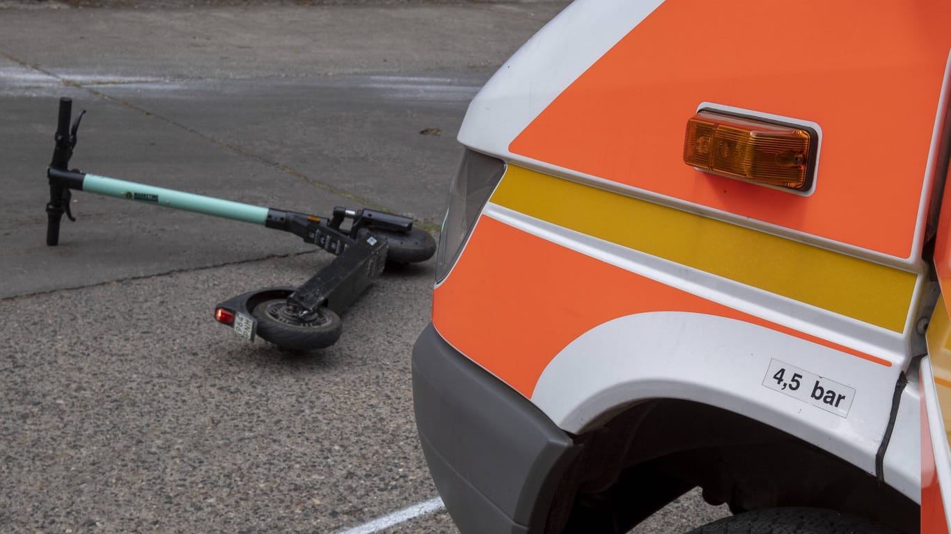 Ein Rettungswagen vor einem umgestürzten E-Scooter (Symbolbild): Als ein Zeuge den Fahrer des Transporters auf den Unfall aufmerksam machte, fuhr er an die Unfallstelle zurück.