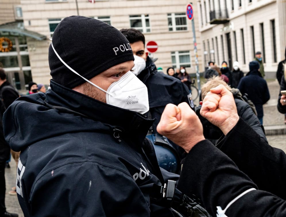 Ein Demonstrant zeigt einem Polizisten die Fäuste