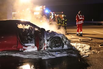 Der gelöschte Sportwagen vor den Einsatzkräfte: Der Mercedes brannte vollkommen aus.