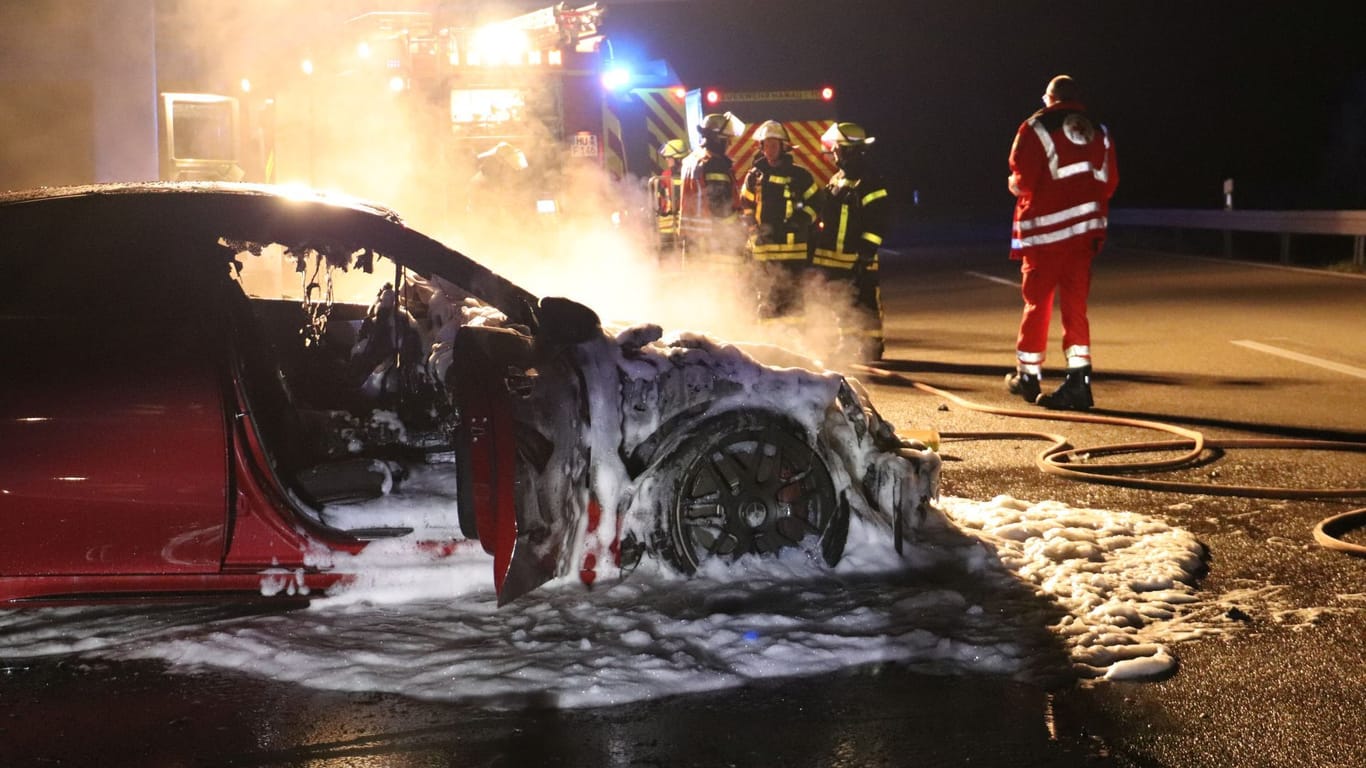 Der gelöschte Sportwagen vor den Einsatzkräfte: Der Mercedes brannte vollkommen aus.