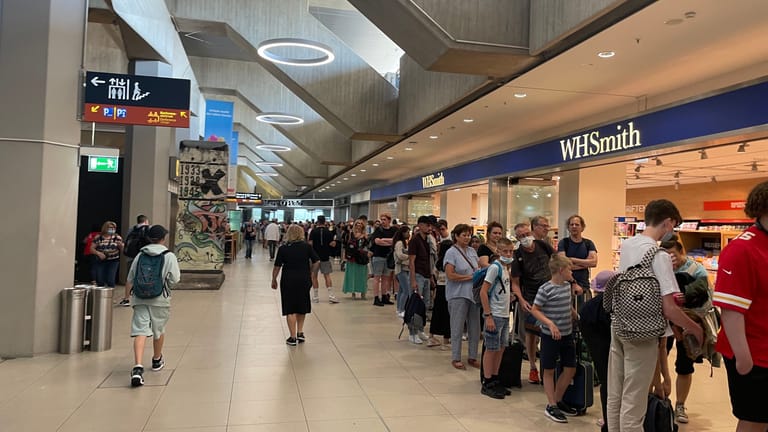Reisende warten in einer Schlange am Flughafen Köln Bonn: Zum Ferienstart in NRW sind die Flughäfen stark belastet.