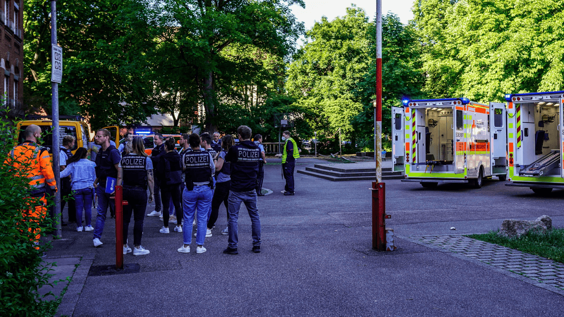 Einsatzkräfte stehen vor der Schule: Auch ein Hubschrauber ist mit dabei.